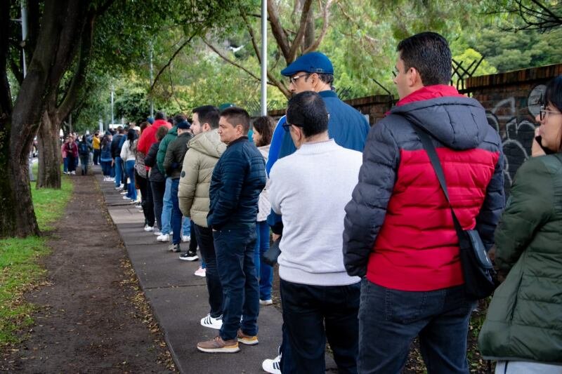 Personas en una oficina de salud revisando documentos de inscripción