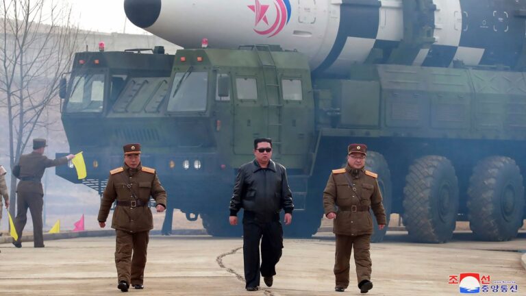 Kim Jong-un en reunión del Comité Central del Partido del Trabajo de Corea, con mapa de fondo