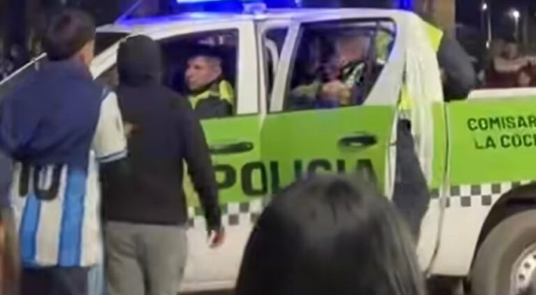 Personas rodean un móvil policial durante incidentes en La Cocha