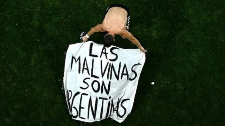 Giovani Lo Celso mostrando una bandera con la leyenda Las Malvinas son argentinas