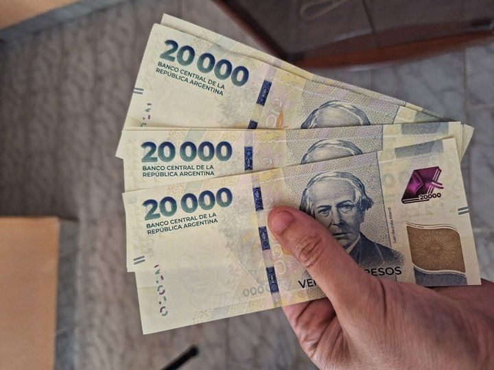 Persona revisando documentos financieros y calculando tasas de interés