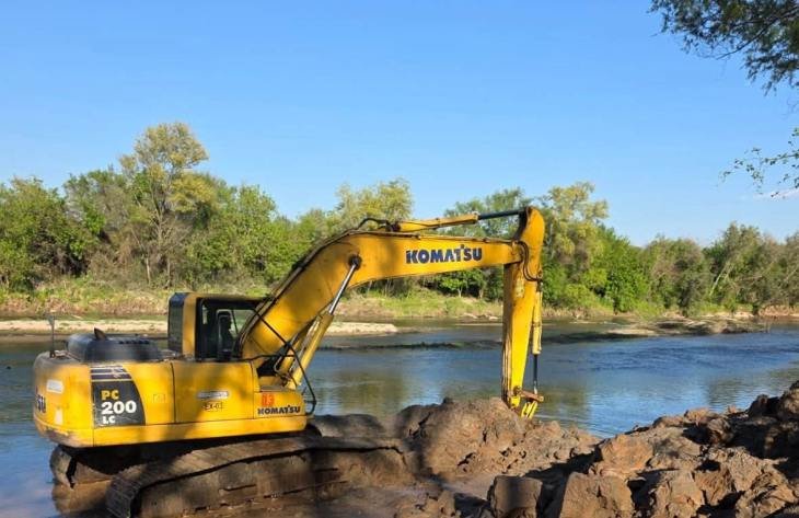 Maquinaria trabajando en el río Marapa, en el sector del Paso La Tala, para mejorar el escurrimiento y reforzar la protección de la zona.