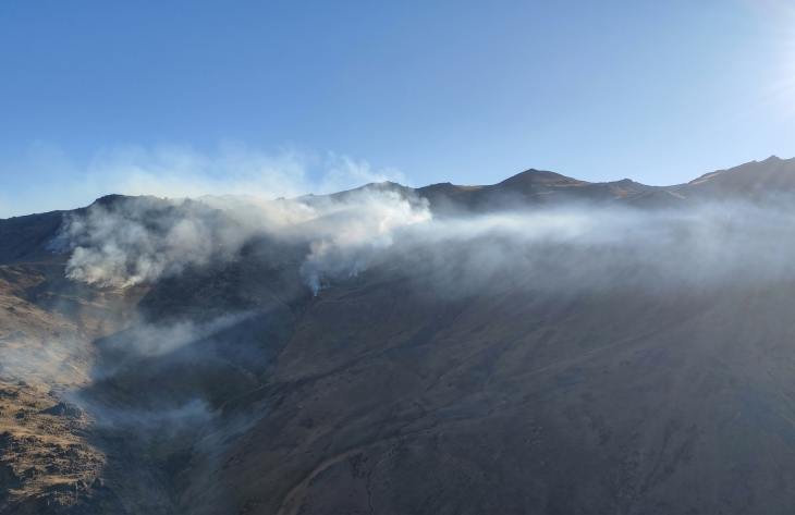 Brigadistas forestales y medios aéreos durante un operativo contra incendios en zona de alta montaña de Tucumán