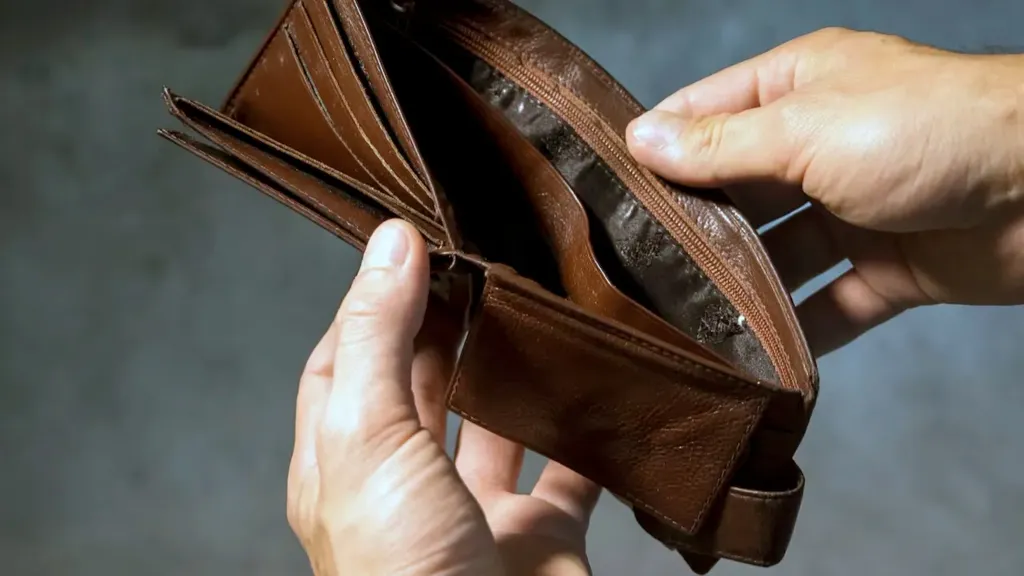 Persona revisando cuentas y billetes sobre una mesa