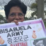 Marta, una mujer tucumana de 77 años, sostiene un cartel que dice "Bisabuela army" en las afueras del Estadio Único de La Plata.