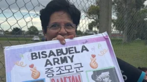 Marta, una mujer tucumana de 77 años, sostiene un cartel que dice "Bisabuela army" en las afueras del Estadio Único de La Plata.